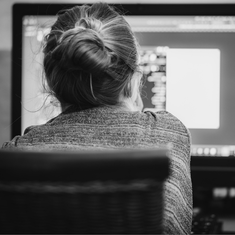A woman staring at a computer screen, showing signs of screen apnea