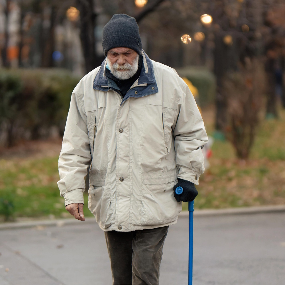 An elderly man walking along a quiet outdoor path in the morning, part of a healthy daily habit