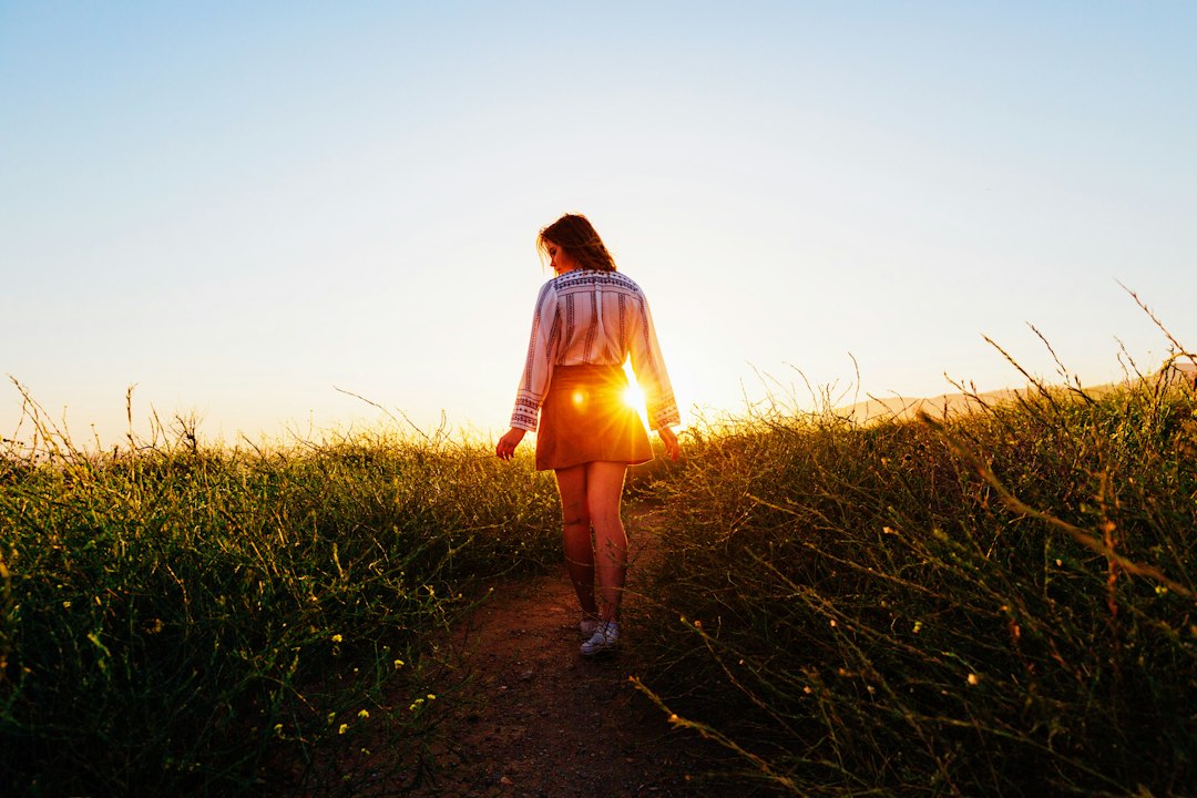 A woman walking outdoors on a path in the afternoon
