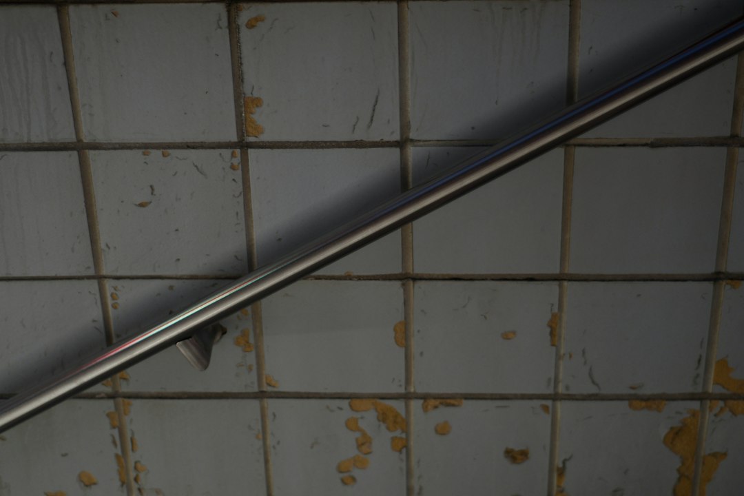 A stainless steel grab bar installed in a bathroom to reduce fall risk