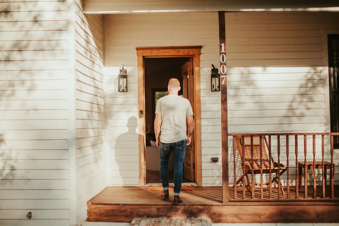 A man standing on a porch in front of a house