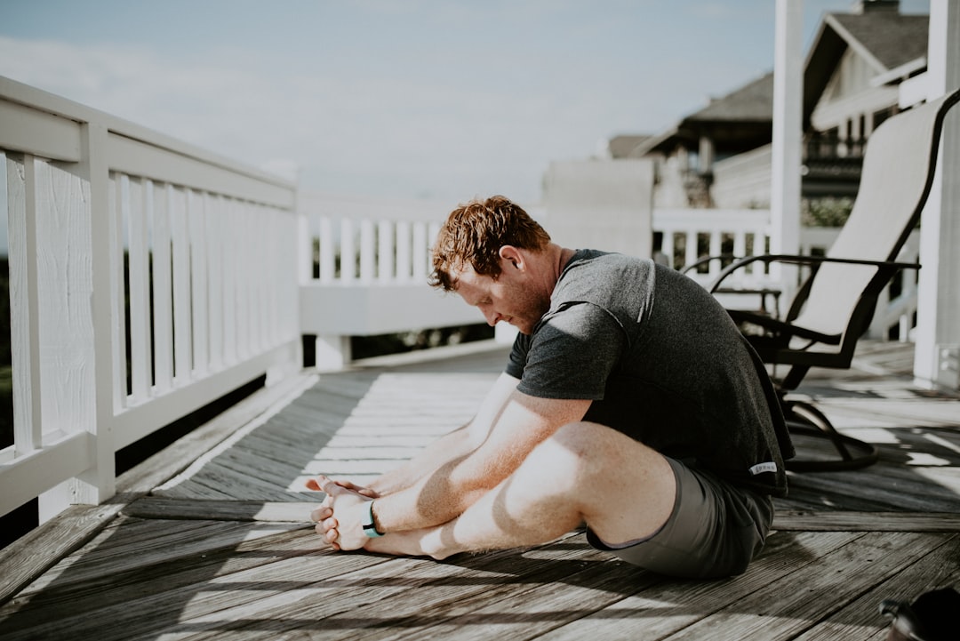 A man doing gentle stretches on a porch
