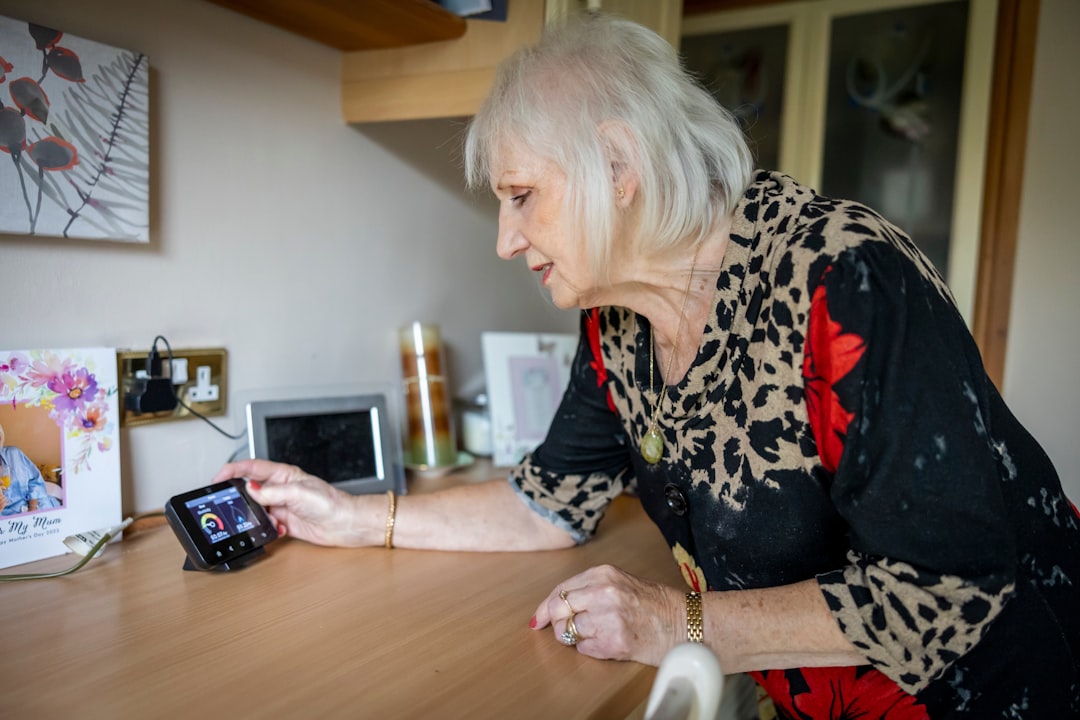 An older woman looking at a cell phone on a table