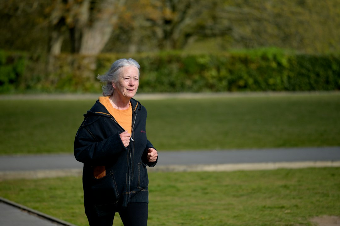 Older woman jogging in a park, staying active for joint mobility