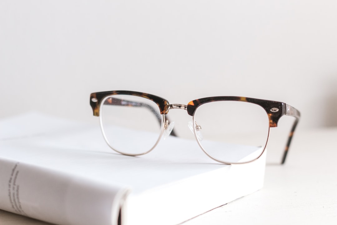 A pair of clear reading glasses resting on an open book