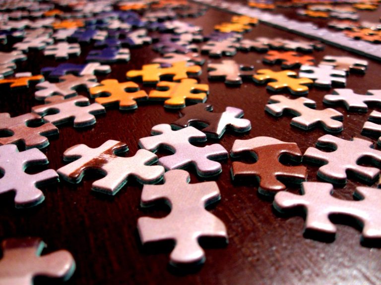 Colorful jigsaw puzzle pieces scattered on a dark surface