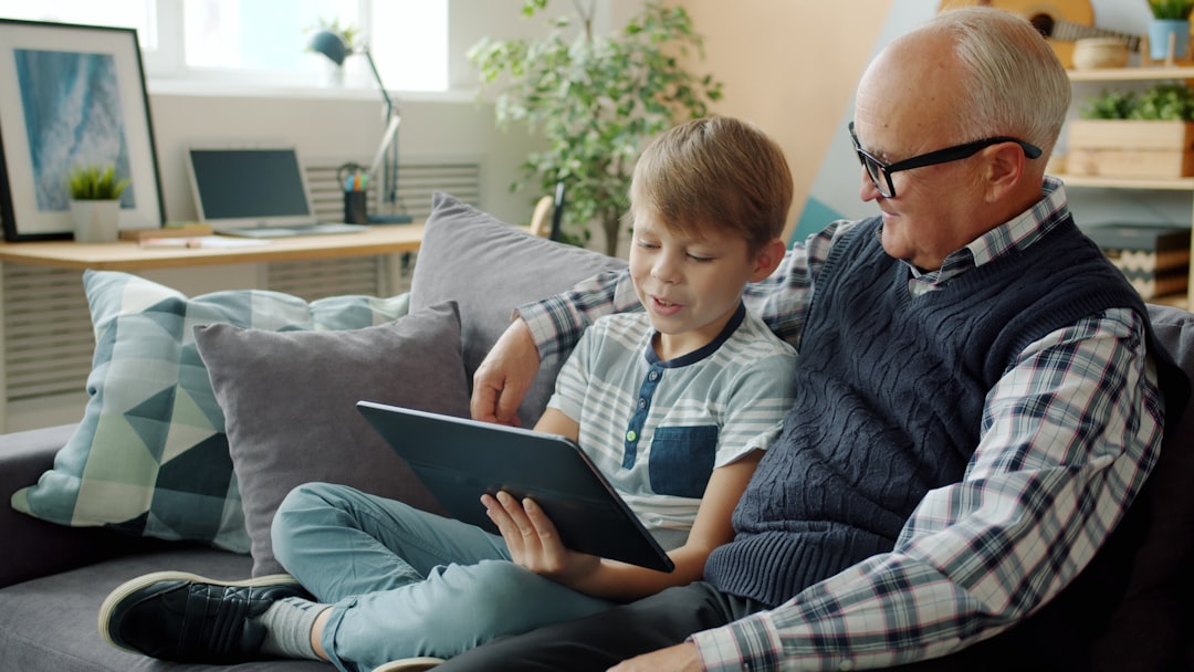 A grandfather and grandchild looking at a tablet together