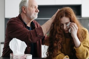 An elderly man consoling a woman
